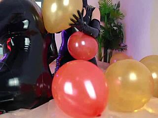 Младата жена в латексов котен костюм се забавлява с балон