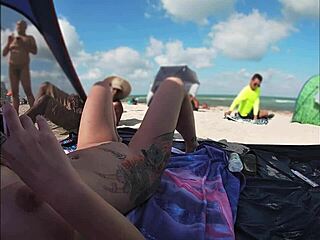 Voyeurisme op het strand met een naakte vrouw en meerdere mannen die kijken