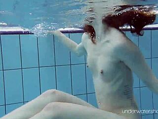 一个大股的年轻人在游泳池里脱下衣服和变性