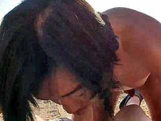 Alaston aasialainen mies antaa syvän kurkun suihinoton valkoiselle miehelle Välimeren rannalla