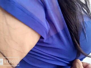 Această femeie matură și frumoasă se bucură să-și mângâie sânii mari în timp ce poartă o rochie albastră într-un videoclip de casă