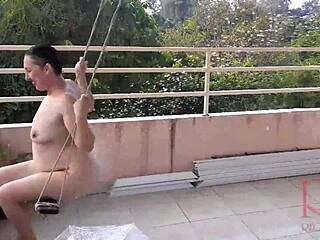 Eine Hausfrau gönnt sich schwingen ohne Unterwäsche, während sie in einem klassischen Video in voller Länge Schutz vor Regen unter einem Sonnenschirm sucht